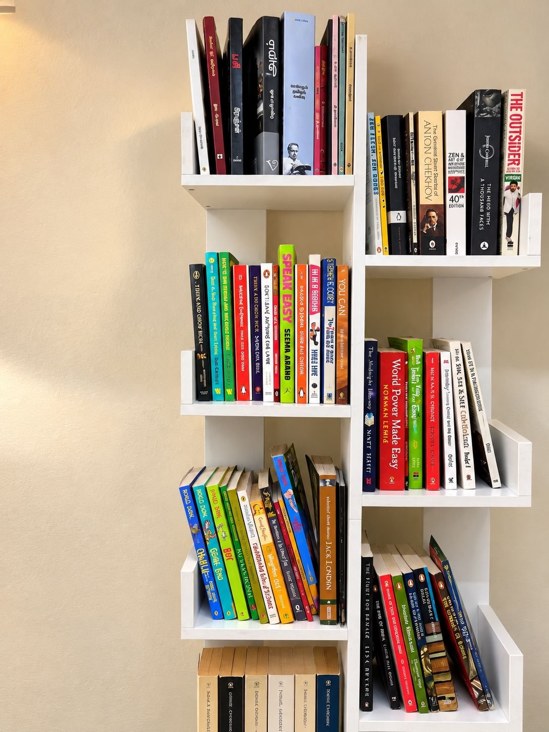 A tall white bookshelf packed with novels, non-fiction and children's books.